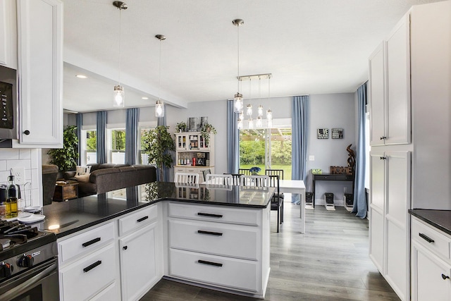 82 Dickens St, Spring Arbor, MI 49283 - kitchen with dark countertops, white cabinetry, dark wood finished floors, decorative light fixtures, and recessed lighting