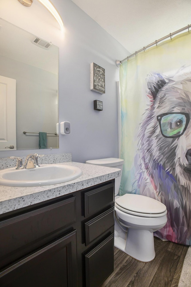 82 Dickens St, Spring Arbor, MI 49283 - bathroom featuring wood finished floors, toilet, vanity, and a shower with shower curtain