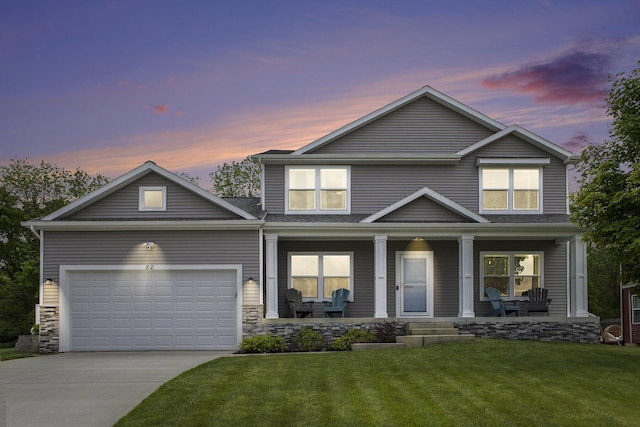82 Dickens St, Spring Arbor, MI 49283 - view of front of home with concrete driveway, an attached garage, covered porch, a lawn, and stone siding