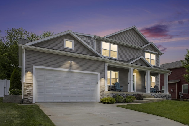 82 Dickens St, Spring Arbor, MI 49283 - view of front of home with covered porch, stone siding, concrete driveway, and a front lawn