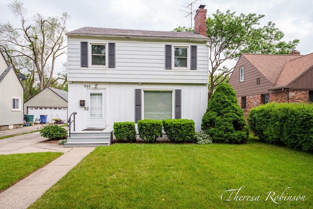 844 Dorroll St NE, Grand Rapids, MI 49505 - colonial house with an outdoor structure, a front yard, a chimney, and a detached garage