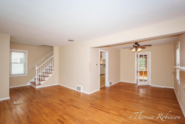 844 Dorroll St NE, Grand Rapids, MI 49505 - unfurnished living room featuring stairway, light wood-style floors, baseboards, and a ceiling fan