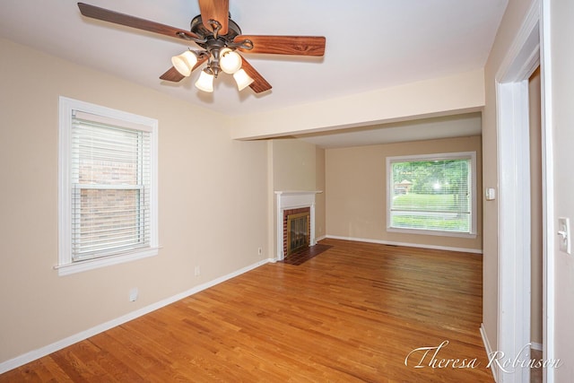 844 Dorroll St NE, Grand Rapids, MI 49505 - unfurnished living room featuring light wood-style floors, a fireplace, a ceiling fan, and baseboards
