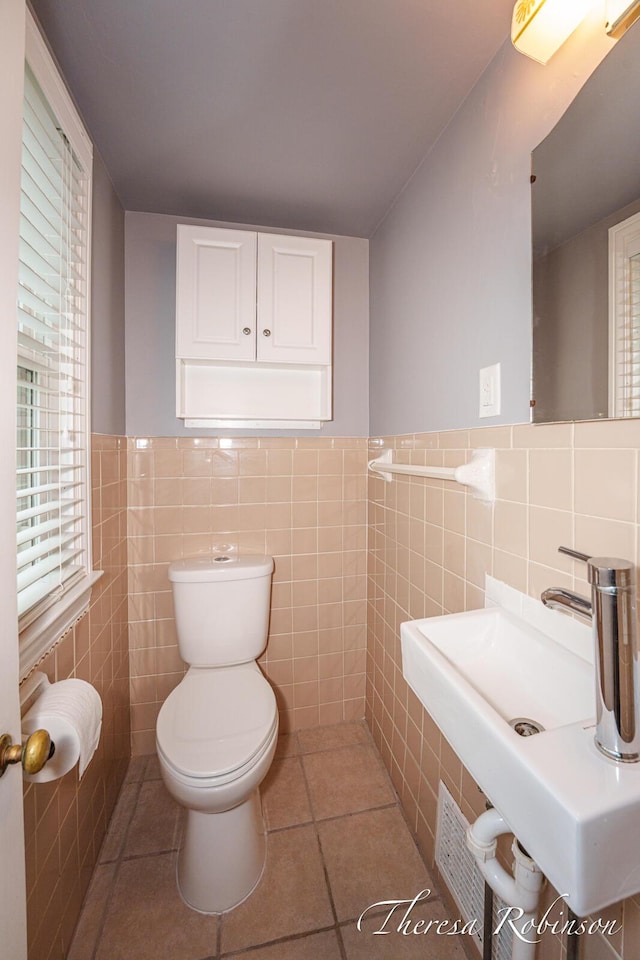844 Dorroll St NE, Grand Rapids, MI 49505 - bathroom with tile walls, toilet, a sink, tile patterned flooring, and a wainscoted wall