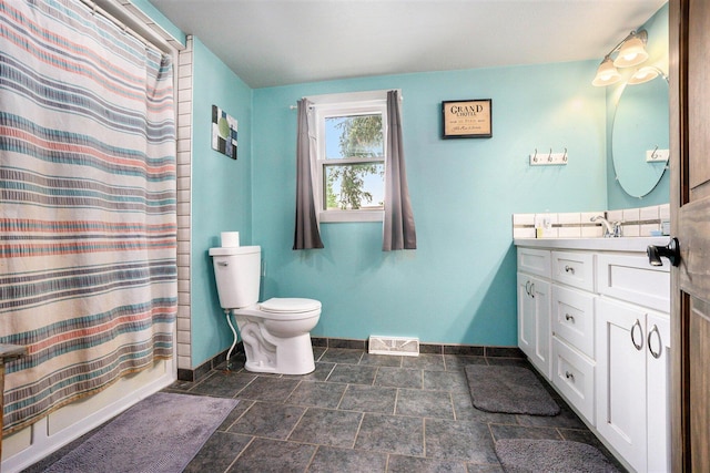 1027 E Railroad St, Hastings, MI 49058 - bathroom with baseboards, vanity, toilet, and stone finish floors