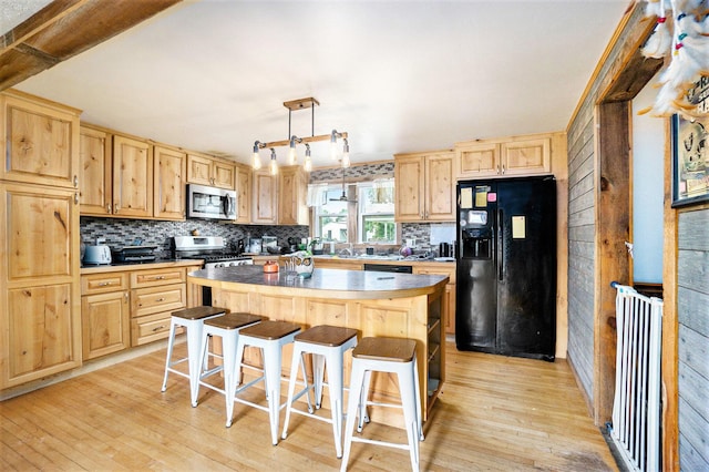 1027 E Railroad St, Hastings, MI 49058 - kitchen featuring black appliances, light brown cabinets, light wood-style flooring, and backsplash