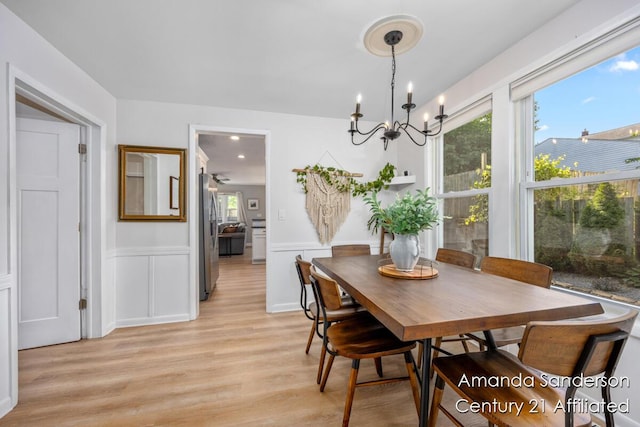 620 Emerald Ave NE, Grand Rapids, MI 49503 - dining space featuring a chandelier, plenty of natural light, light wood-style floors, a wainscoted wall, and a decorative wall