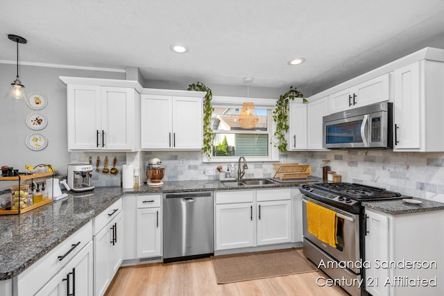 620 Emerald Ave NE, Grand Rapids, MI 49503 - kitchen with appliances with stainless steel finishes, a sink, a peninsula, white cabinetry, and recessed lighting
