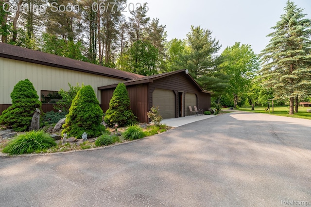 3591 Curry Rd, Caro, MI 48723 - view of property exterior featuring a detached garage, an outdoor structure, and view of scattered trees