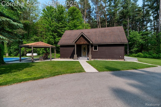 3591 Curry Rd, Caro, MI 48723 - view of front of property featuring a gazebo, a front lawn, an outdoor pool, and roof with shingles
