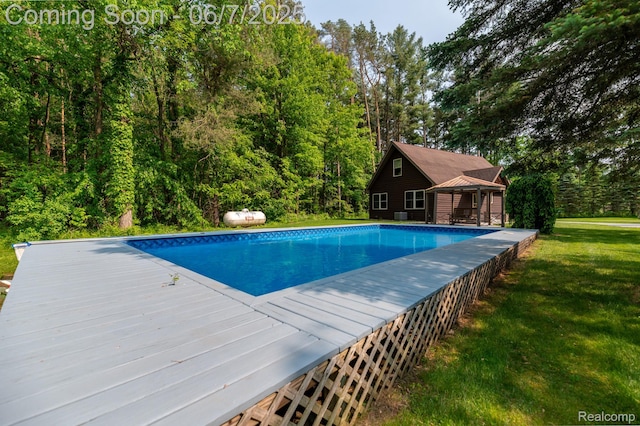 3591 Curry Rd, Caro, MI 48723 - swimming pool featuring a lawn, a gazebo, a deck, and a forest view