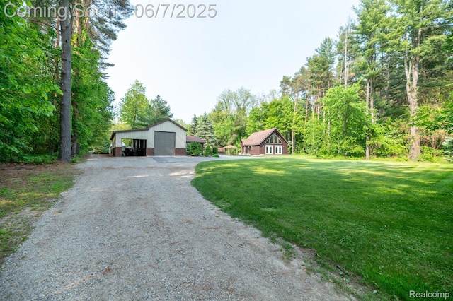 3591 Curry Rd, Caro, MI 48723 - view of front of home with a detached garage, a front yard, an outdoor structure, and gravel driveway