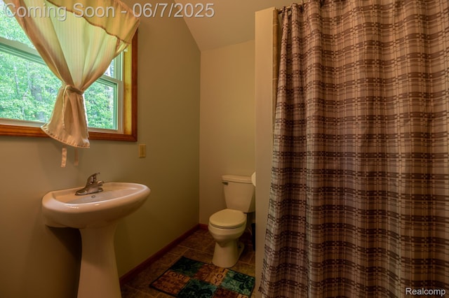 3591 Curry Rd, Caro, MI 48723 - bathroom featuring toilet, vaulted ceiling, tile patterned flooring, a shower with curtain, and baseboards