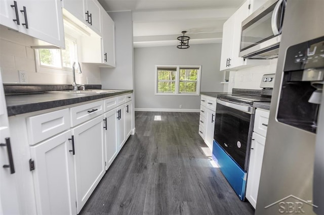 2832 N W River Rd, Sanford, MI 48657 - kitchen with appliances with stainless steel finishes, dark countertops, dark wood-style flooring, white cabinetry, and baseboards