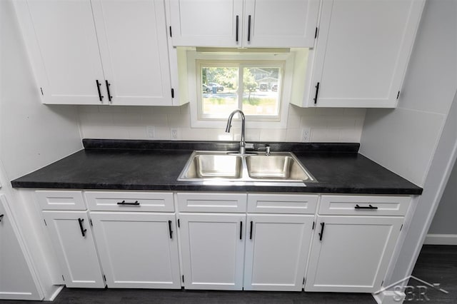 2832 N W River Rd, Sanford, MI 48657 - kitchen with a sink, white cabinets, dark countertops, and tasteful backsplash