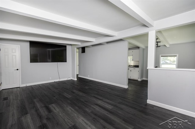 2832 N W River Rd, Sanford, MI 48657 - unfurnished living room featuring beam ceiling, baseboards, and dark wood-style flooring