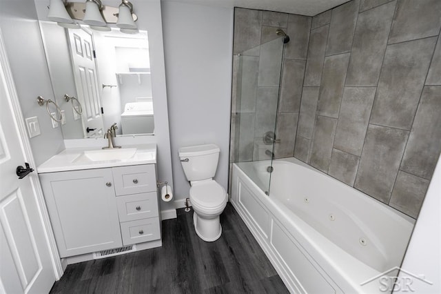 2832 N W River Rd, Sanford, MI 48657 - full bathroom featuring toilet, wood finished floors, vanity, a combined bath / shower with jetted tub, and baseboards