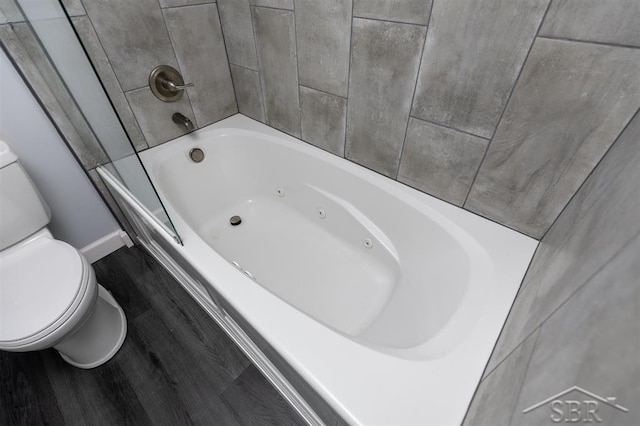 2832 N W River Rd, Sanford, MI 48657 - bathroom with toilet, wood finished floors, and baseboards