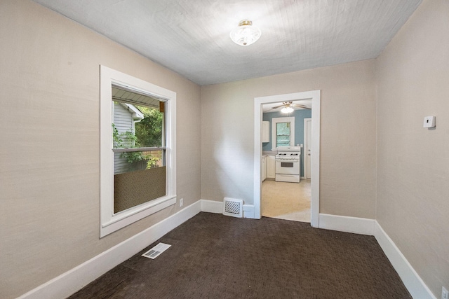 904 Riverview Ave, Lansing, MI 48915 - spare room with dark carpet, baseboards, and a ceiling fan
