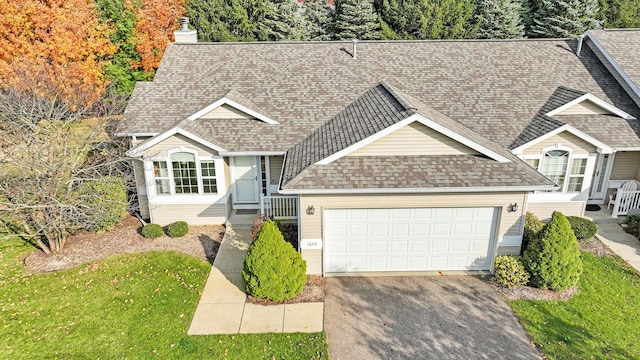 1649 Quail Run Dr, Kalamazoo, MI 49009 - view of front of house featuring roof with shingles, driveway, an attached garage, a chimney, and a front lawn