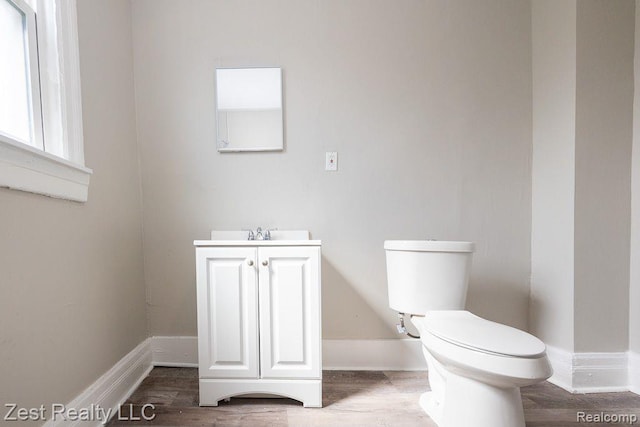 2977 Canton St, Detroit, MI 48207 - half bathroom with toilet, vanity, baseboards, and wood finished floors