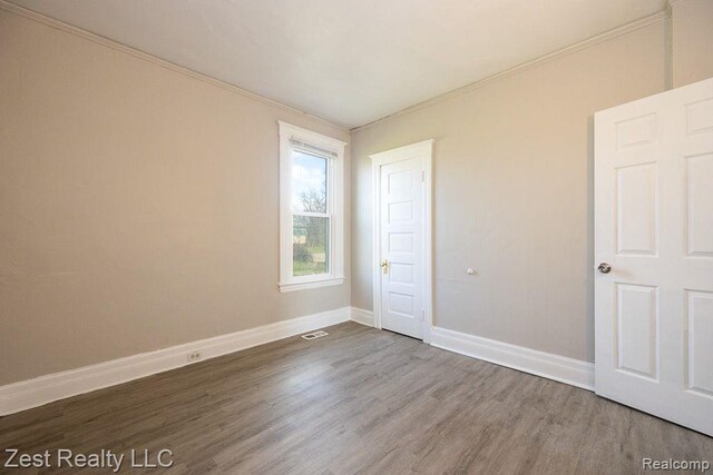 2977 Canton St, Detroit, MI 48207 - unfurnished bedroom with wood finished floors, baseboards, and crown molding