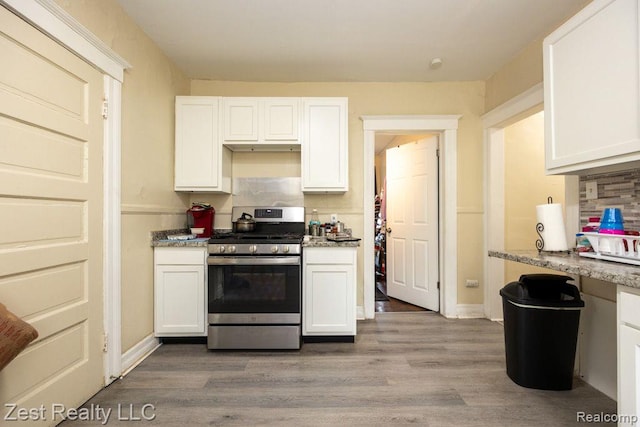 2977 Canton St, Detroit, MI 48207 - kitchen featuring stainless steel range with gas cooktop, white cabinets, wood finished floors, and light stone countertops