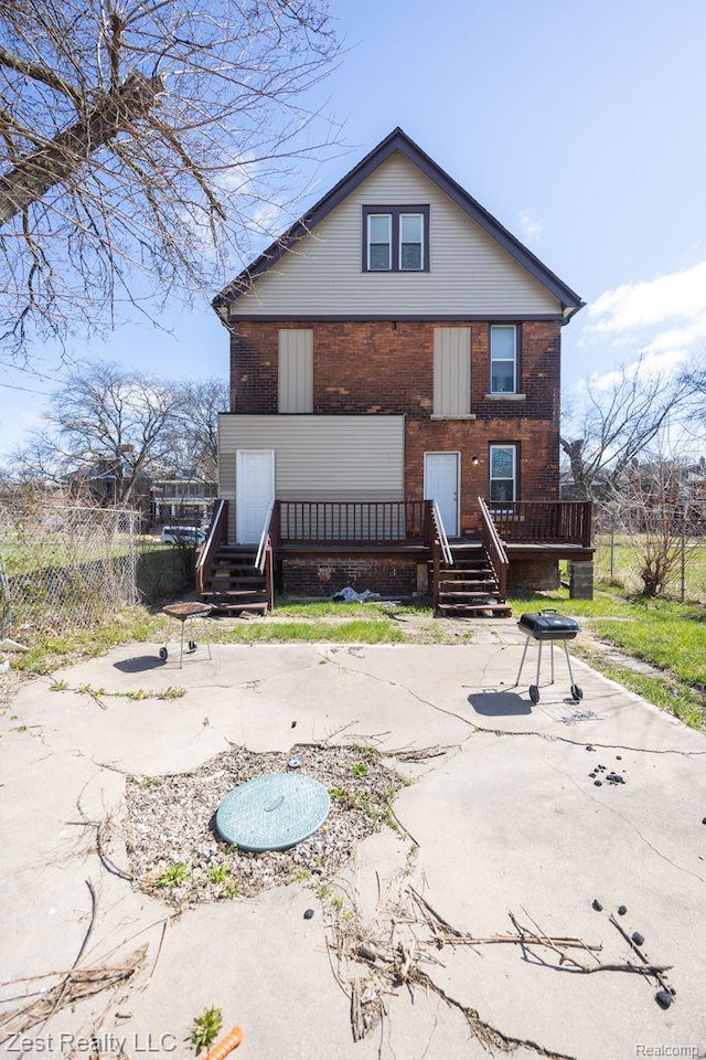 2977 Canton St, Detroit, MI 48207 - rear view of property featuring brick siding, a wooden deck, and a patio area