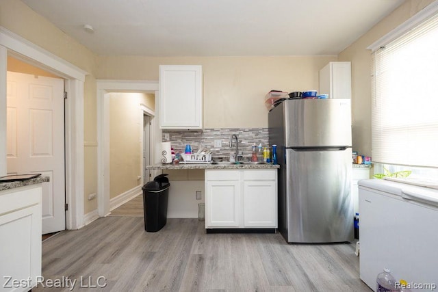 2977 Canton St, Detroit, MI 48207 - kitchen featuring freestanding refrigerator, healthy amount of natural light, and white cabinets