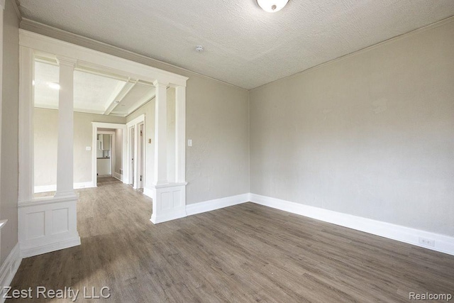 2977 Canton St, Detroit, MI 48207 - unfurnished room with decorative columns, dark wood-type flooring, and baseboards
