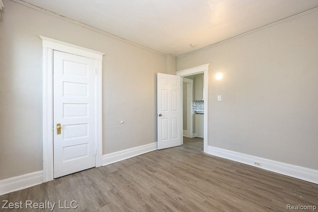 2977 Canton St, Detroit, MI 48207 - unfurnished bedroom with wood finished floors, ornamental molding, and baseboards