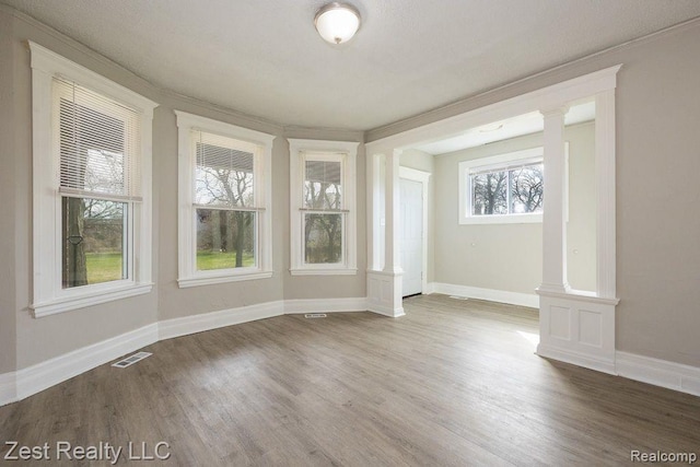 2977 Canton St, Detroit, MI 48207 - spare room featuring ornate columns, wood finished floors, ornamental molding, and baseboards