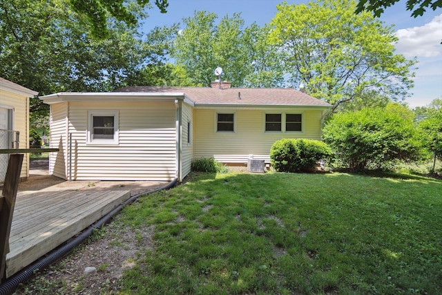 1279 Cunningham, Jackson, MI 49201 - back of property with a wooden deck, a yard, a chimney, and central AC unit
