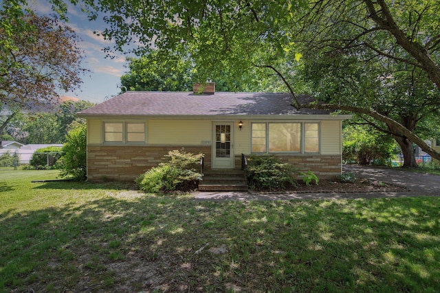 1279 Cunningham, Jackson, MI 49201 - view of front facade with a yard, a chimney, and stone siding