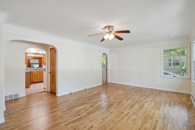 1279 Cunningham, Jackson, MI 49201 - empty room with arched walkways, ceiling fan, light wood-type flooring, and baseboards
