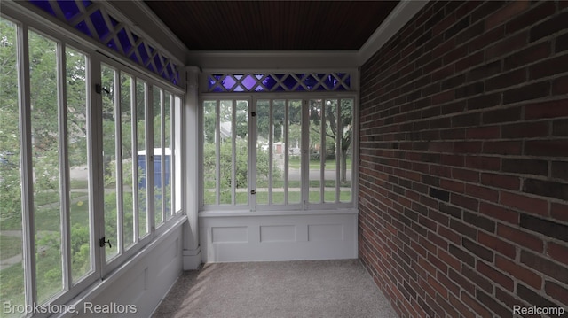 22101 Francis St, Dearborn, MI 48124 - unfurnished sunroom featuring carpet floors, plenty of natural light, wood ceiling, and brick wall