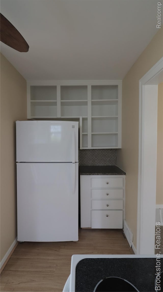22101 Francis St, Dearborn, MI 48124 - kitchen with freestanding refrigerator, open shelves, dark countertops, and light wood-style flooring
