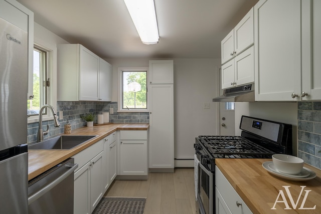 7936 Whitehall Rd, Whitehall, MI 49461 - kitchen featuring wooden counters, stainless steel appliances, a sink, under cabinet range hood, and a baseboard radiator