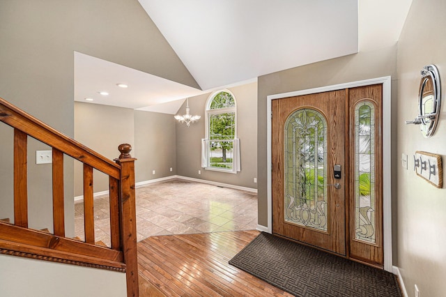 224 S Jameson St, New Buffalo, MI 49117 - entryway with lofted ceiling, a chandelier, baseboards, wood-type flooring, and stairway