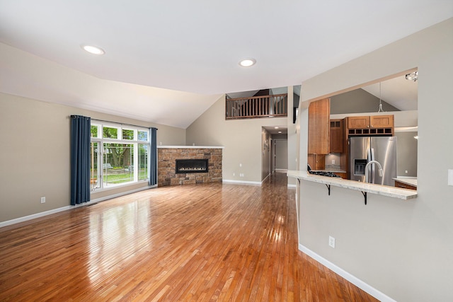 224 S Jameson St, New Buffalo, MI 49117 - unfurnished living room featuring vaulted ceiling, light wood-style floors, a fireplace, baseboards, and recessed lighting