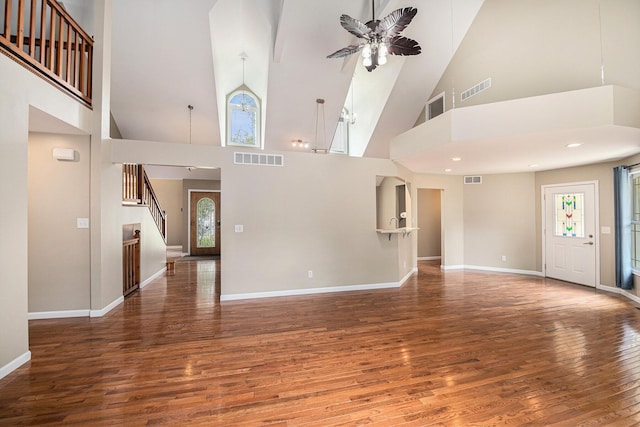 224 S Jameson St, New Buffalo, MI 49117 - unfurnished living room featuring high vaulted ceiling, wood finished floors, stairs, baseboards, and a ceiling fan