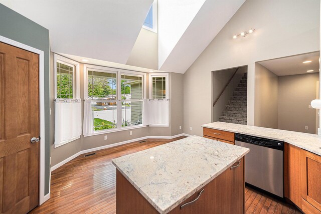 224 S Jameson St, New Buffalo, MI 49117 - kitchen featuring stainless steel dishwasher, hardwood / wood-style floors, brown cabinetry, a kitchen island, and baseboards
