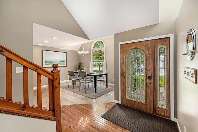 224 S Jameson St, New Buffalo, MI 49117 - foyer entrance with wood-type flooring, vaulted ceiling, a chandelier, and baseboards