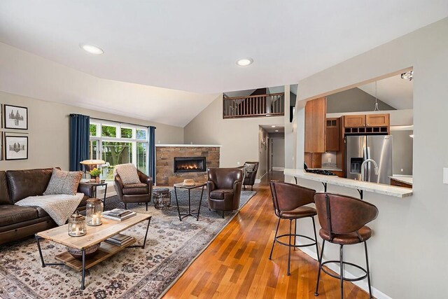 224 S Jameson St, New Buffalo, MI 49117 - living room featuring vaulted ceiling, wood finished floors, a fireplace, baseboards, and recessed lighting