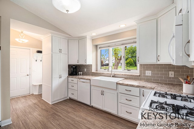 5896 Rollaway Dr NE, Comstock Park, MI 49321 - kitchen featuring white appliances, a sink, lofted ceiling, tasteful backsplash, and white cabinetry
