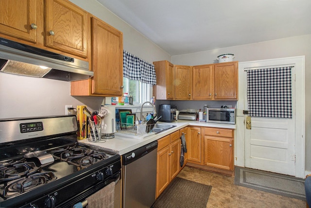 1019/1021 N Michigan Ave, Howell, MI 48843 - kitchen featuring stainless steel appliances, under cabinet range hood, light countertops, a sink, and brown cabinets
