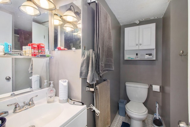 1019/1021 N Michigan Ave, Howell, MI 48843 - bathroom with tile patterned flooring, toilet, vanity, and a textured ceiling