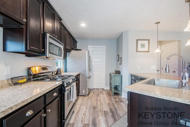 881 Cobblestone Way Dr SE, Byron Center, MI 49315 - kitchen with appliances with stainless steel finishes, a sink, light wood-style floors, light countertops, and dark brown cabinetry