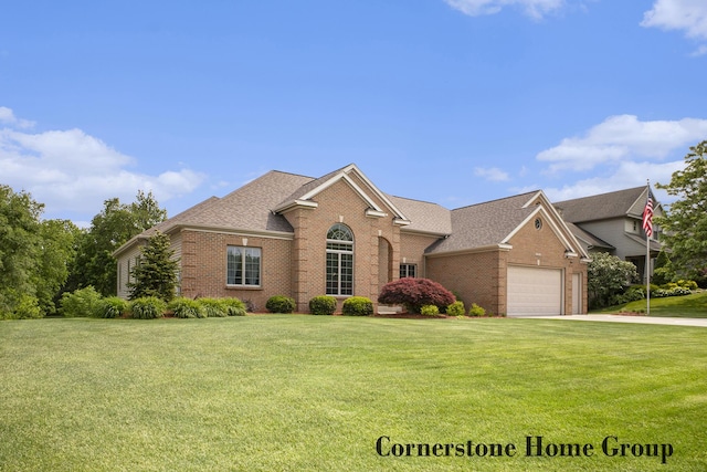 5273 S Silverstone Dr NE, Comstock Park, MI 49321 - view of front facade featuring brick siding, a front lawn, an attached garage, and a shingled roof
