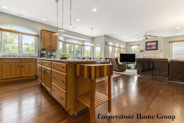 5273 S Silverstone Dr NE, Comstock Park, MI 49321 - kitchen with a ceiling fan, dark wood finished floors, recessed lighting, a kitchen bar, and a fireplace